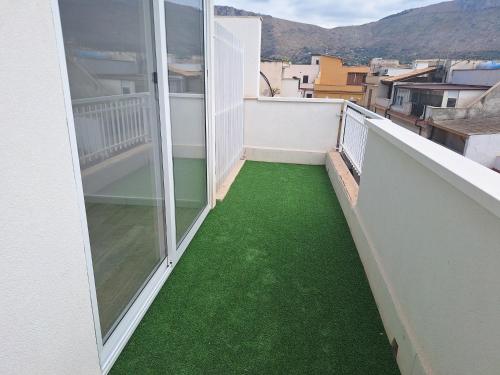 a balcony with green flooring on a building at Domus Levante in Terrasini
