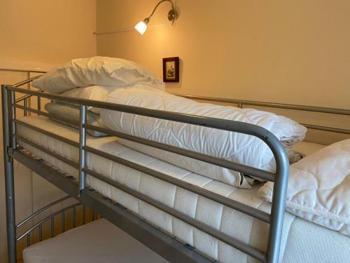 a bunk bed with white sheets and pillows on it at Ferienwohnungen Waldsicht und Dorfsicht in Winkel