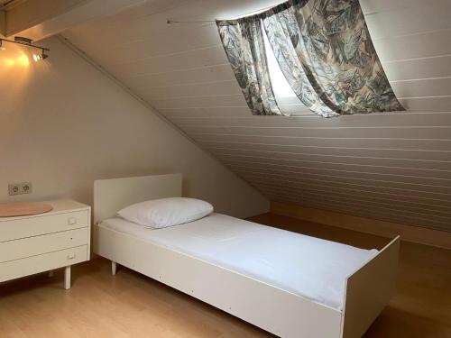 a small bed in a room with a window at Ferienwohnungen Waldsicht und Dorfsicht in Winkel