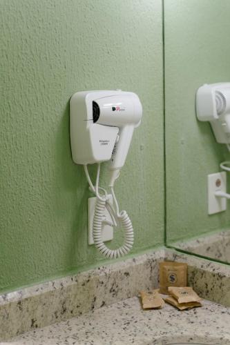a phone on a wall in a bathroom at Strassen Hotel in Goiânia