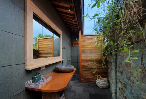 ein Bad mit einem Waschbecken und einem Spiegel in der Unterkunft Yoga Searcher Bali in Uluwatu