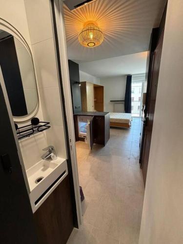 une salle de bain avec un lavabo et un miroir dans l'établissement Studio à Courbevoie 92, à Courbevoie