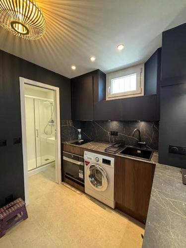 une cuisine avec une machine à laver et un évier dans l'établissement Studio à Courbevoie 92, à Courbevoie