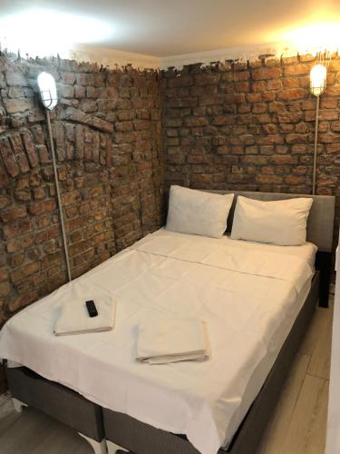 a bed in a room with a brick wall at Cihangir apart in Istanbul