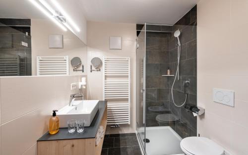 a bathroom with a sink and a shower at Natur & Aktiv Hotel Rogen in Mühlbach
