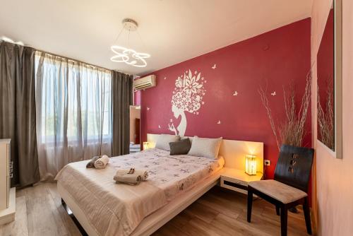 a bedroom with a bed and a red wall at Apartments Rosina in Plovdiv