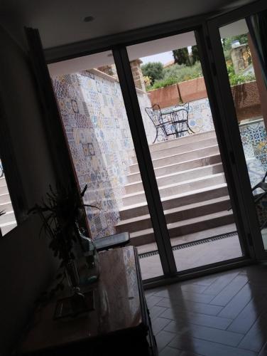 a glass door leading to a balcony with a glass table at Bed&Rooms Villa La Gatta in Vatolla
