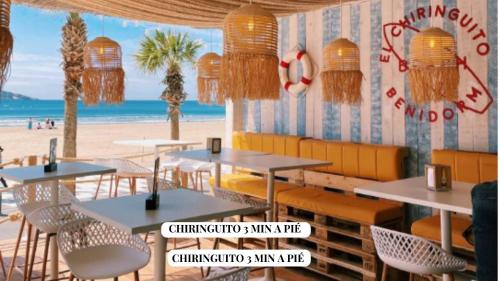 a restaurant on the beach with tables and chairs at Apartamento Completo Torresol I in Benidorm