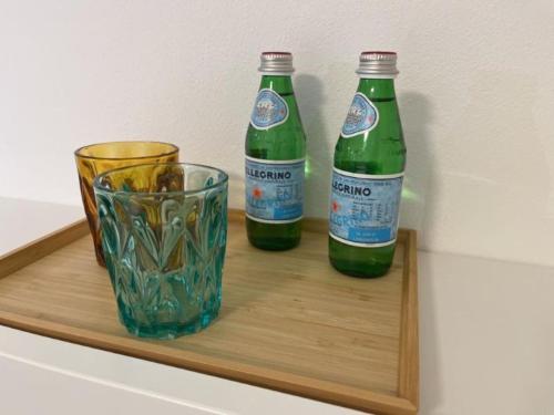 two bottles and a glass on a wooden shelf at B&B San Francesco Class in San Pellegrino Terme