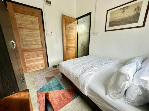 a bedroom with a bed and a wooden door at Ferringhi Inn 51 in Batu Ferringhi