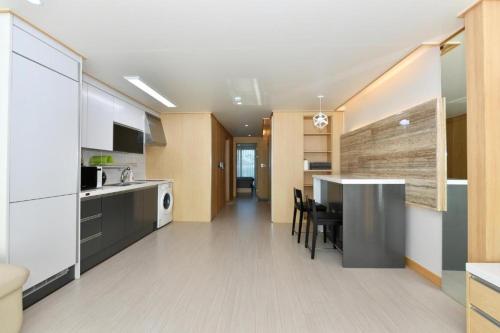 a kitchen with a table and a counter top at Sokcho Daemyung Heidi Pension in Sokcho