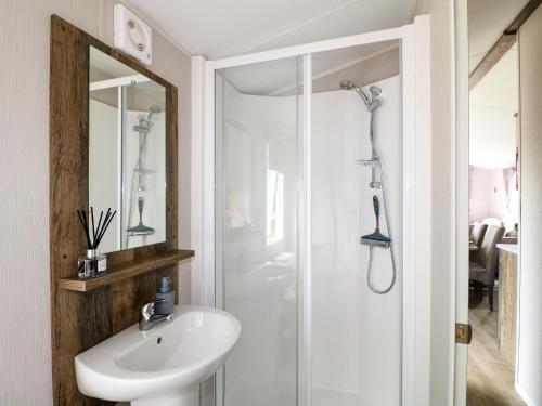 um banheiro com uma pia branca e um chuveiro em Peacock Lodge em Coalville