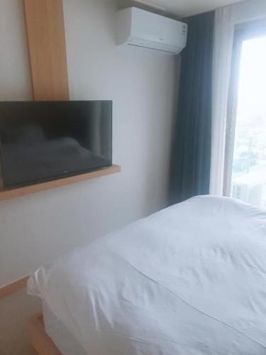 a bedroom with a white bed and a window at Sokcho Daemyung Heidi Pension in Sokcho