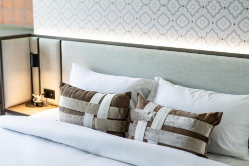 a bedroom with a white bed with two pillows at WE HOTEL RIVERFRONT in Bang Su