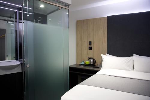 a bedroom with a bed and a glass shower at The Z Hotel Bath in Bath