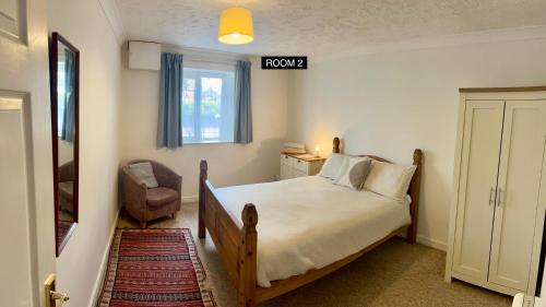 a bedroom with a bed and a chair and a window at Casa di Qeis a double bedroom ground floor flat with free parking in Chesterton
