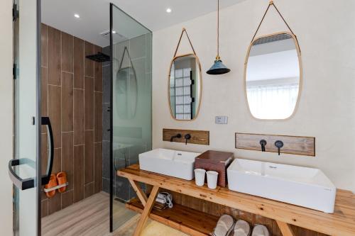 a bathroom with two sinks and two mirrors at 问安民宿（黄山风景区店） in Huangshan Scenic Area