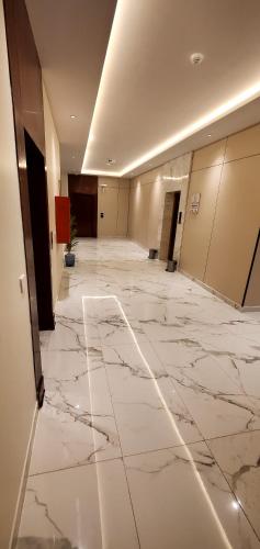 an empty lobby with marble floors and a large hallway at قصر أباهي للوحدات السكنية المفروشة in Al Kharj