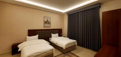 a hotel room with two beds and a window at قصر أباهي للوحدات السكنية المفروشة in Al Kharj