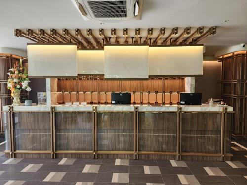 a bar in a restaurant with wooden cabinets at WE HOTEL RIVERFRONT in Bang Su