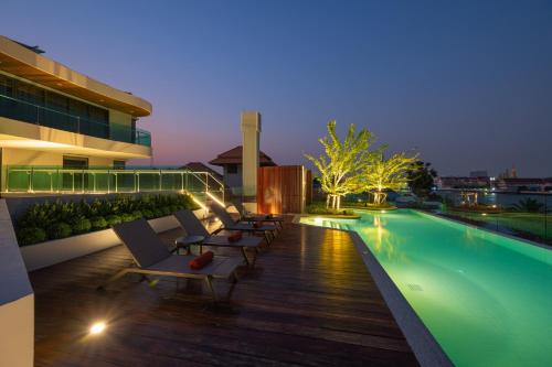 a pool on the roof of a building at night at WE HOTEL RIVERFRONT in Bang Su