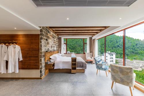 una camera da letto con un letto e un muro di pietra di 问安民宿（黄山风景区店） a Mount Huangshan