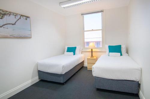 two twin beds in a room with a window at Windsor Cottage - CBD central location in Albany