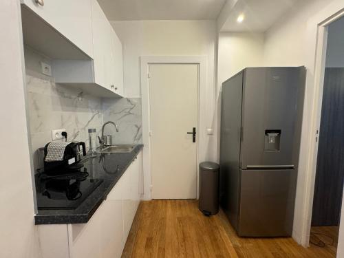 une cuisine avec un évier et un réfrigérateur dans l'établissement Marais, Sainte-croix Bretonnerie - 6 places, à Paris