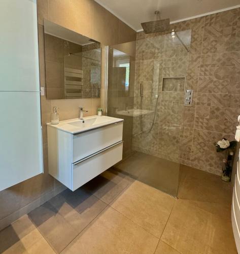 une salle de bain avec un lavabo et une douche dans l'établissement Au petit paradis, à Nîmes