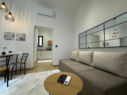 een woonkamer met een bank en een tafel bij Apartman A in the heart of Ferhadija - Parking available in Sarajevo