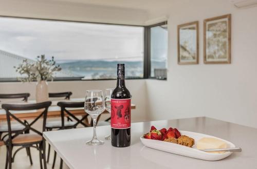 a bottle of wine and a plate of fruit on a table at Vancouver Vista in Albany