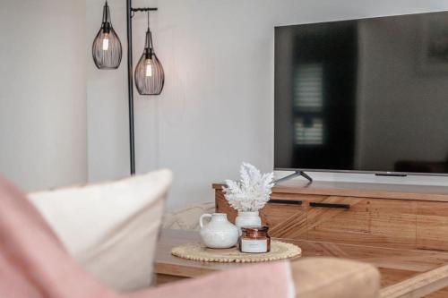 a living room with a tv and a vase on a table at Vancouver Vista in Albany