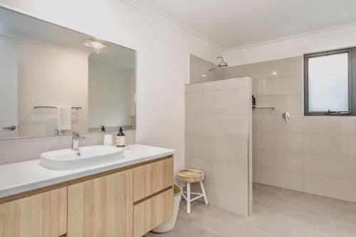 Un baño blanco con lavabo y ducha. en Vancouver Vista, en Albany