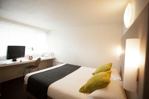 Cette chambre d'hôtel dispose d'un lit avec des oreillers jaunes. dans l'établissement Campanile Avallon, à Sauvigny-le-Bois