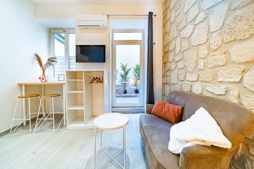 un salon avec un canapé et un mur en pierre dans l'établissement 