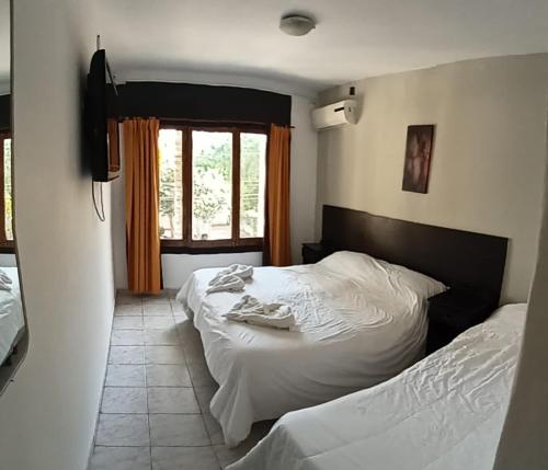 a bedroom with two beds and a window at Palmas del Lago in Villa Carlos Paz