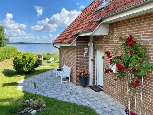 a brick house with a white bench in the yard at Ferienhaus Biberburg in Sternberg
