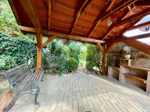 una panchina posta sotto un tetto di legno su un patio di Zaži Toskánsko v Nitre - celý dom pri ferrate a Nitra