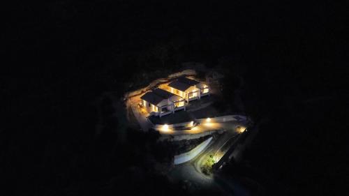 an aerial view of a house in the water at night at LefkoParga Luxury Suites in Parga