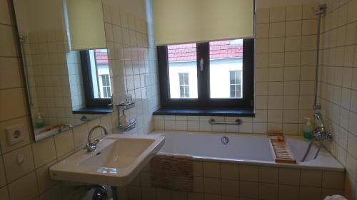 a bathroom with a tub and a sink and a mirror at exklusive Ferienwohnung in Theaternähe in Meiningen