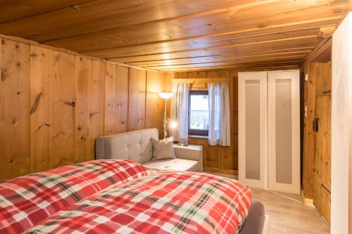 a bedroom with a bed and a chair and a window at Der kleine Stadl in Oberried