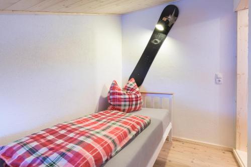 a bed with a baseball bat on the wall at Der kleine Stadl in Oberried
