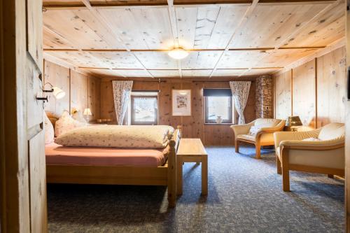 a bedroom with a bed and a couch in a room at Der große Stadl in Oberried