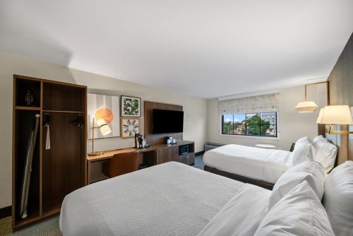 a hotel room with two beds and a desk at Holiday Inn Niagara Falls State Park Entry by IHG in Niagara Falls