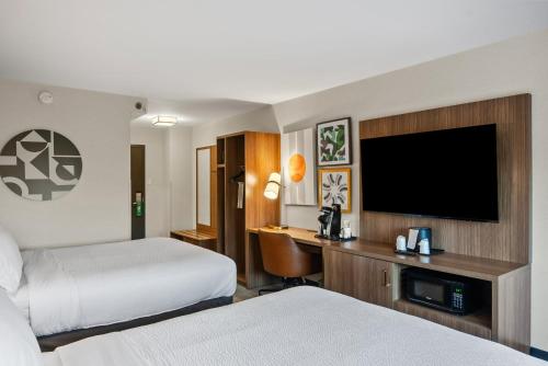 a hotel room with two beds and a flat screen tv at Holiday Inn Niagara Falls State Park Entry by IHG in Niagara Falls