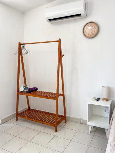 a room with a shelf and a clock on a wall at Rincón Caribeño - Amplio estudio en Cozumel in Cozumel