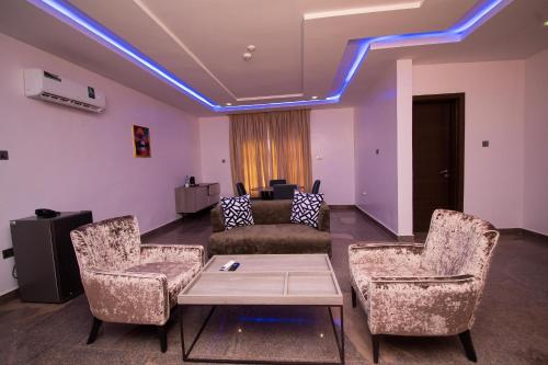 a living room with a couch and chairs and a table at Marchforte Courtyard Hotel & Suites in Ibadan