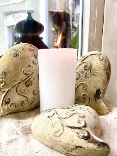 a candle sitting next to some rocks and a window at Hotel Fischerhaus in Starnberg