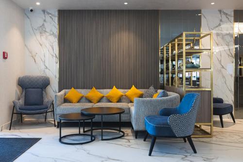 a lobby with a couch with yellow pillows at Crowne Plaza Constanta - Mamaia Beach by IHG in Mamaia
