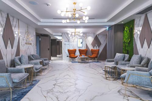 a lobby with chairs and tables and a chandelier at Crowne Plaza Constanta - Mamaia Beach by IHG in Mamaia
